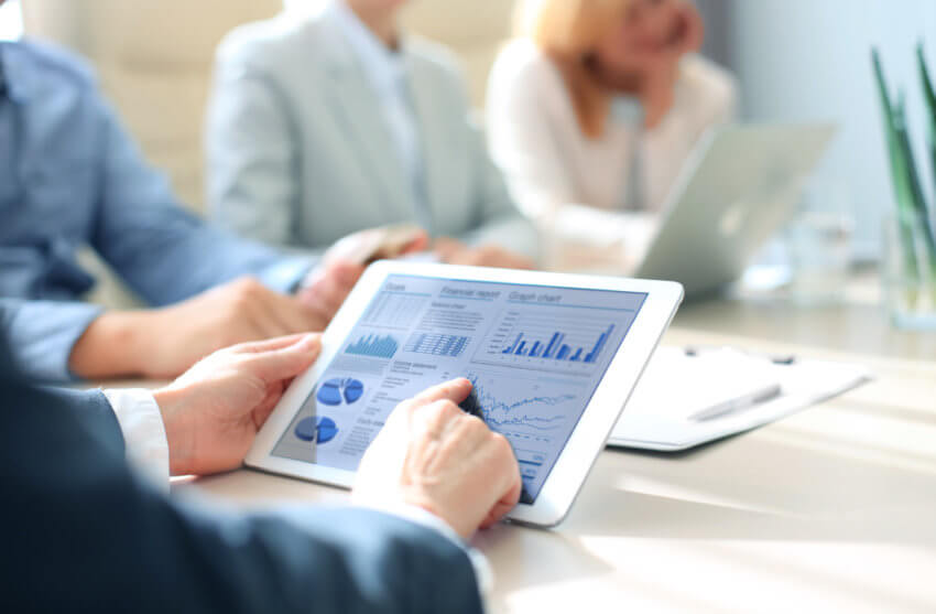 Person using iPad for work with graphs on screen