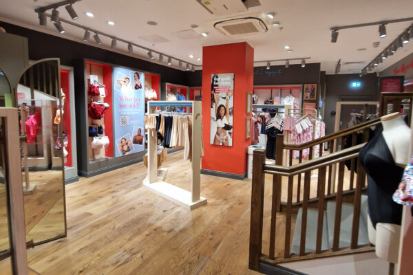 Interior of a Bravissimo store with various lingerie on rails and new ceiling lighting