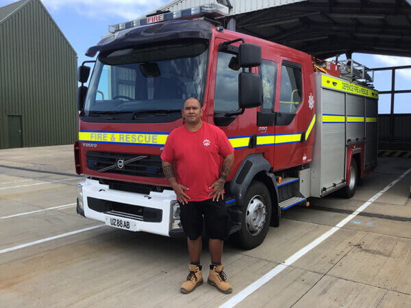 Mitie firefighter standing in front of a fire truck