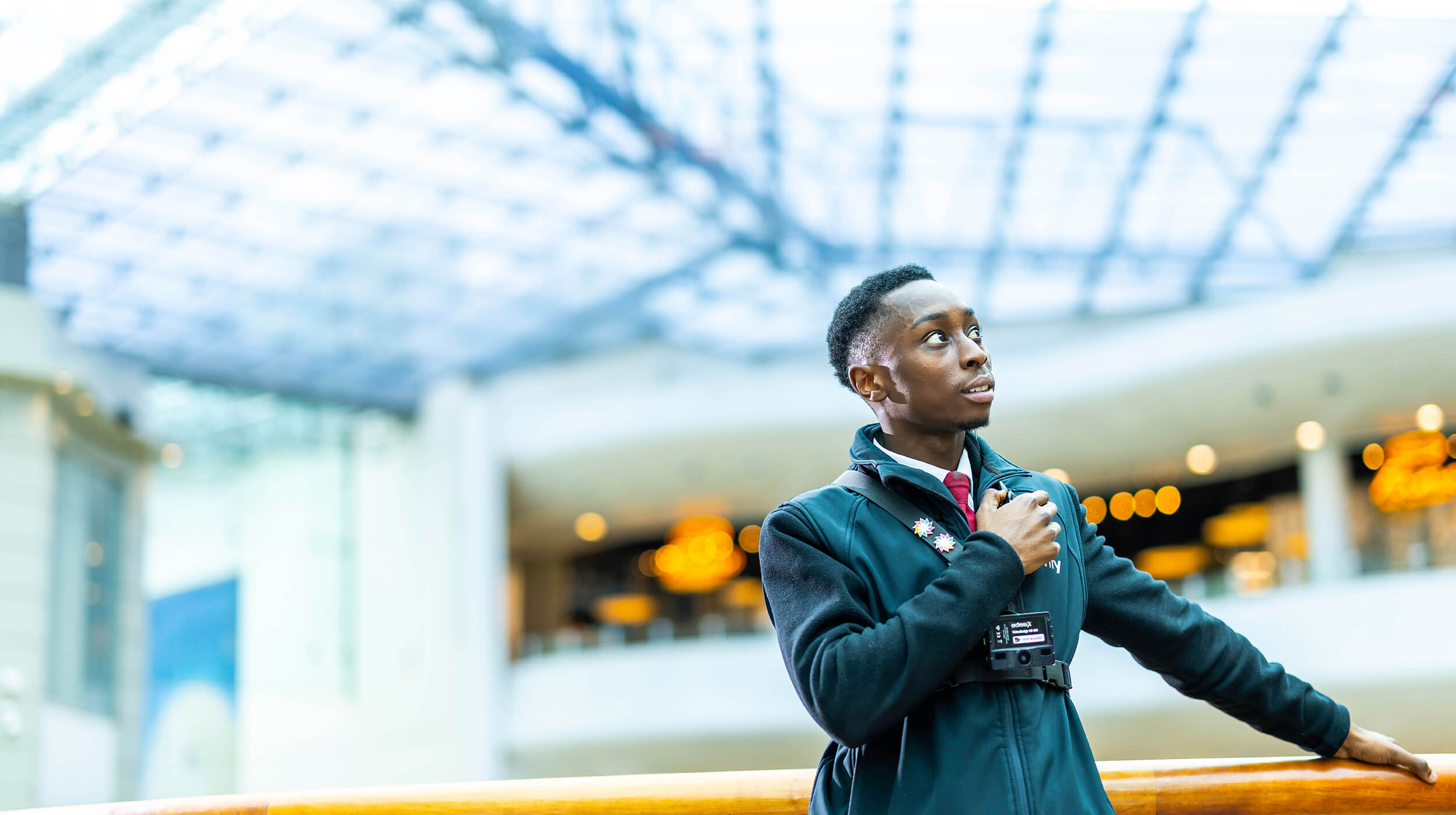 A Mitie black male security guard in a shopping centre