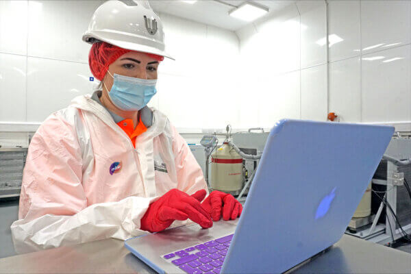 A Mitie colleague working on a laptop in a laboratory setting