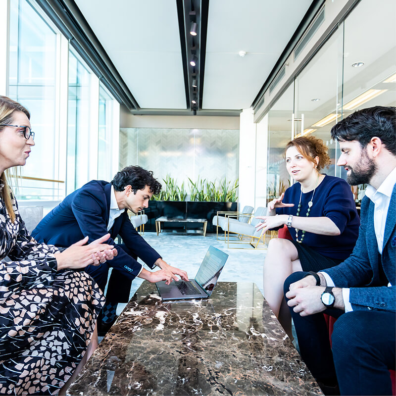 Four people having a meeting around a table in an office