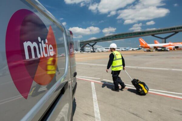 Mitie engineering near the runway at an airport, with Mitie van in foreground